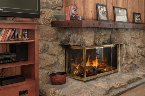a stone fireplace with a fire in it at Beaver Village Unit #0232R in Winter Park