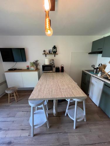une cuisine avec une table au milieu dans l'établissement Studio au coeur de Saint Lary, à Saint-Lary-Soulan