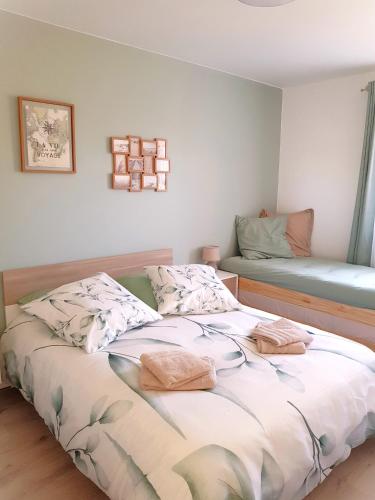 a bedroom with a bed with two pillows on it at La Barak'A in Saint-Laurent-sur-Mer