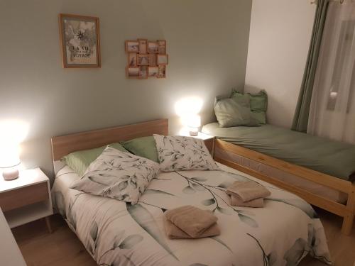 a small bedroom with two beds and two lamps at La Barak'A in Saint-Laurent-sur-Mer