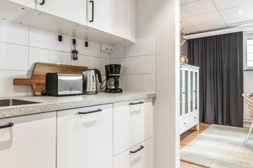 a kitchen with white cabinets and a counter top at STORM studios in Karlskrona