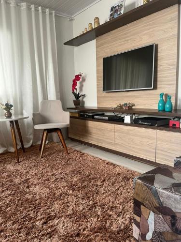 a living room with a flat screen tv on a wall at Quarto acolhedor no Balneario in Florianópolis