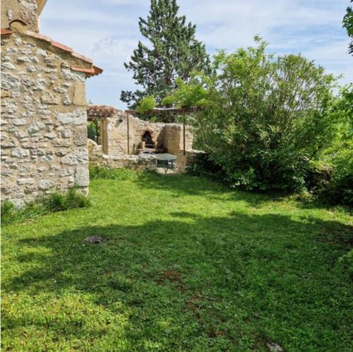 a yard with a stone building and a tree at Hameau de capuran in Blaziert