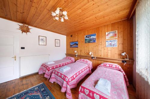 Zimmer mit 4 Betten und Holzdecke in der Unterkunft Appartamento San Lorenzo 2 a Vinigo in Vinigo