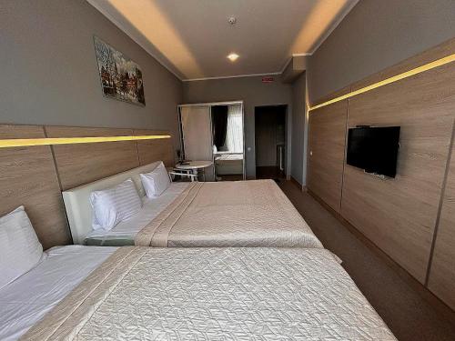 a hotel room with two beds and a flat screen tv at Київські Ночі in Kyiv