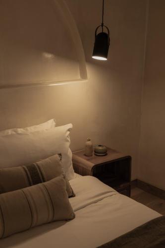 a bedroom with a bed and a table with a lamp at Momi Slow Living Hotel in Hersonissos