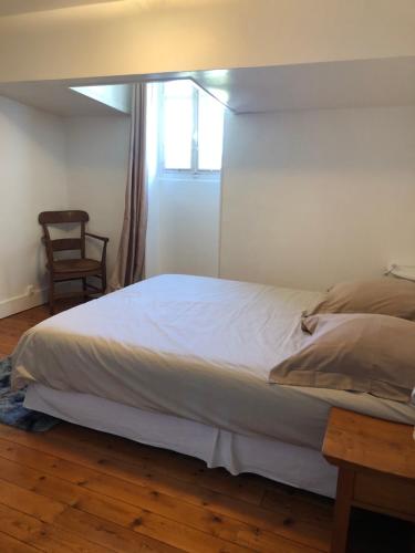 - une chambre avec un lit, une fenêtre et une chaise dans l'établissement Villa, à Saint-Germain-de-Lusignan