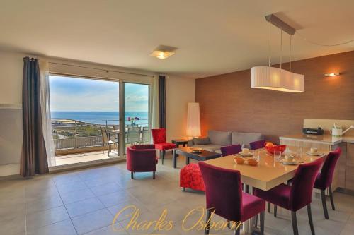 une cuisine et un salon avec une table et des chaises dans l'établissement Le Thau Lido, vue imprenable, garage privé, à Sète