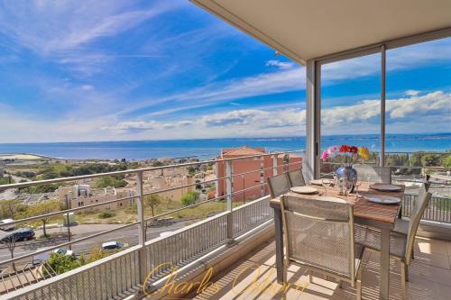 une salle à manger avec une table et des chaises sur un balcon dans l'établissement Le Thau Lido, vue imprenable, garage privé, à Sète