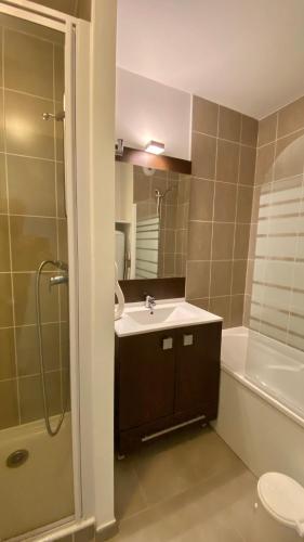 une salle de bain avec un lavabo, une douche et des toilettes dans l'établissement T2 avec piscine en résidence 4 étoiles, à Bénodet