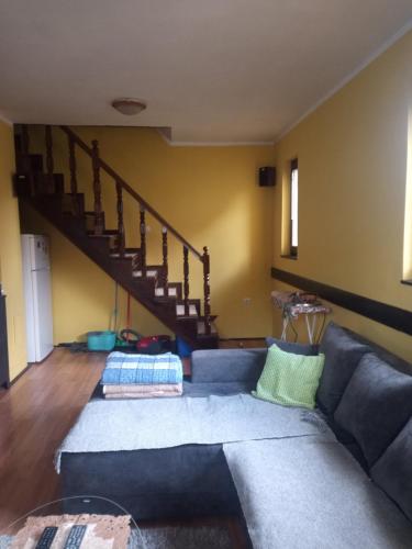 a living room with a couch and a staircase at kuća za odmor Ćira in Kremna