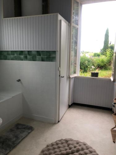 La salle de bains est pourvue d'une douche, d'une fenêtre et d'une porte. dans l'établissement Villa, à Saint-Germain-de-Lusignan