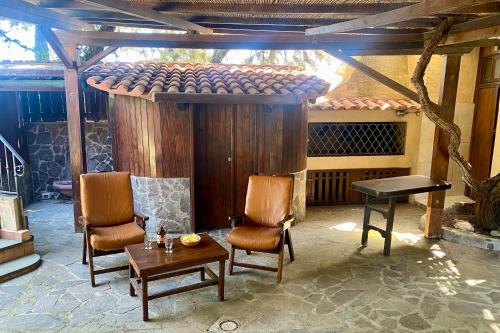 a patio with two chairs and a table and a table at Casa Perassi in Putzu Idu
