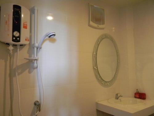 a bathroom with a shower and a sink and a mirror at Rimlay Bungalow in Nai Yang Beach