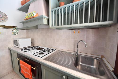 a kitchen with a sink and a stove at Casa Perassi in Putzu Idu