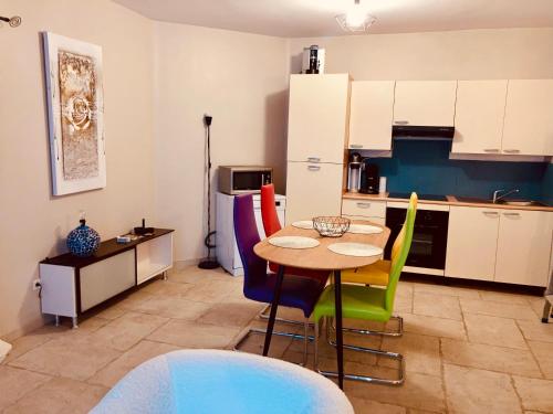 une cuisine avec une table et des chaises colorées dans l'établissement Appartement avec grande terrasse, à Martigues