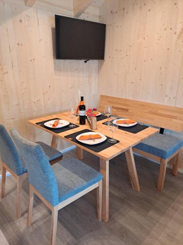 a wooden table with two plates and a bottle of wine at Ferienhaus und Ferienappartements Brunner in Höchst