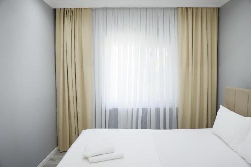 a bedroom with a large white bed and a window at Casa Florya Travel Apartments in Istanbul