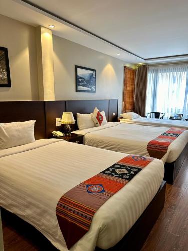 a hotel room with two beds and a window at Sapa Centre Hotel in Sa Pa