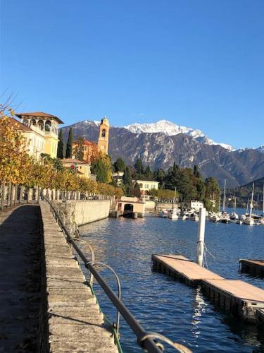 a dock in a body of water with boats at Casa Ambra, 50m vom Comer See, 2 private Parkplätze in Tremezzo
