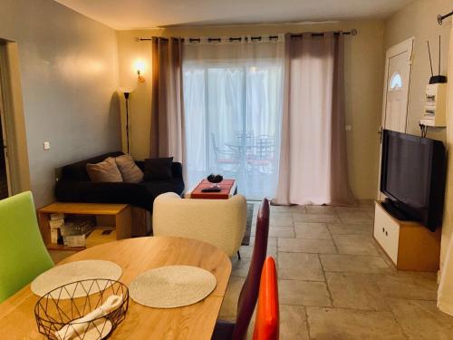un salon avec une table et un canapé dans l'établissement Appartement avec grande terrasse, à Martigues