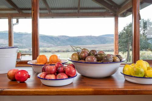 a wooden counter with bowls of fruit on it at The Loop Farmhouse Mooi River in Mooirivier