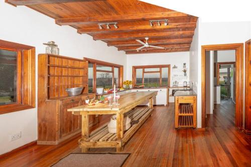 a kitchen with a wooden table and a ceiling fan at The Loop Farmhouse Mooi River in Mooirivier