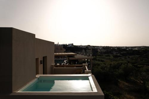 a swimming pool on the side of a house at Momi Slow Living Hotel in Hersonissos
