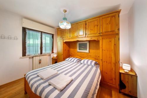 a bedroom with a large bed with wooden cabinets at Casa Gloria a Vinigo in Vinigo