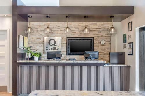 a bar in a lobby with a television and a counter at Quality Inn Daytona Speedway - I-95 in Daytona Beach