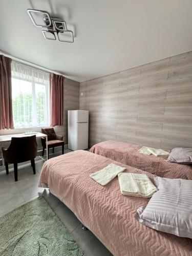 a bedroom with two beds and a desk and a table at Hotel TETRIS Voznesensk in Voznesensk
