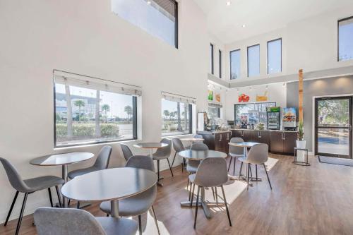a restaurant with tables and chairs and windows at Quality Inn Daytona Speedway - I-95 in Daytona Beach