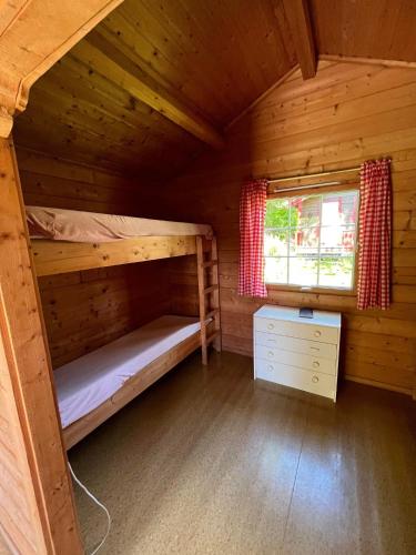 a cabin with two bunk beds and a window at Svindland camping in Kvinesdal