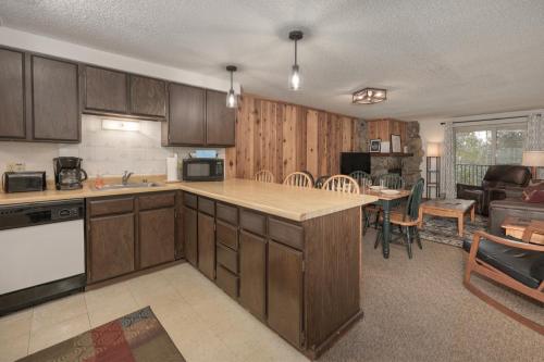 a kitchen with wooden cabinets and a living room at Beaver Village Unit #0623R in Winter Park
