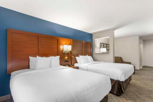 a hotel room with two beds and a blue wall at Comfort Suites Atlanta Airport in Forest Park