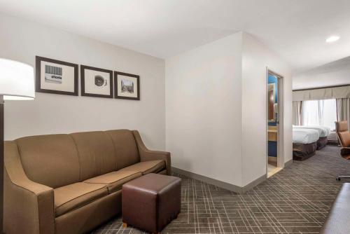 a living room with a couch and a bed at Comfort Suites Atlanta Airport in Forest Park