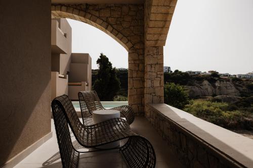 a row of chairs sitting on a balcony with a view at Momi Slow Living Hotel in Hersonissos