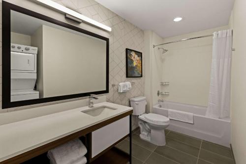 a white bathroom with a sink and a toilet at Everhome Suites Temecula in Temecula