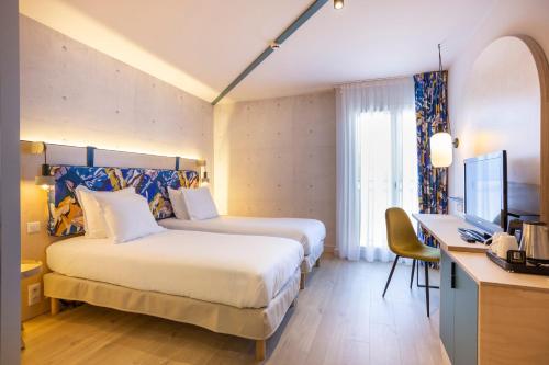 a hotel room with two beds and a desk at Urban Hotel & Spa Aix-les-Bains - BW Signature Collection in Aix-les-Bains