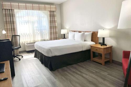 a hotel room with a bed and a window at Country Inn & Suites by Radisson, Tucson Airport, AZ in Tucson