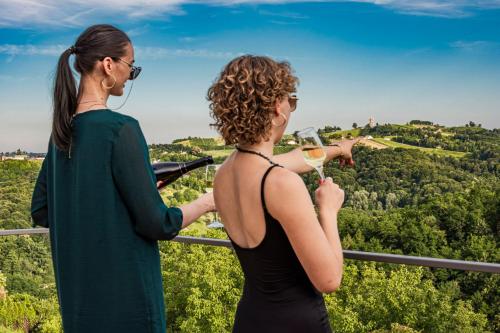 two women standing on top of a tower with a glass of wine at Wellness Počitniška hiša Manja in Ljutomer