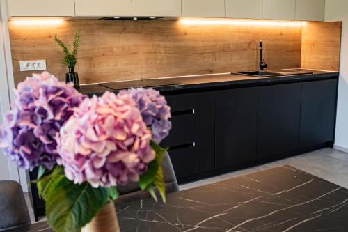 a kitchen with a vase of flowers on a table at Wellness Počitniška hiša Manja in Ljutomer