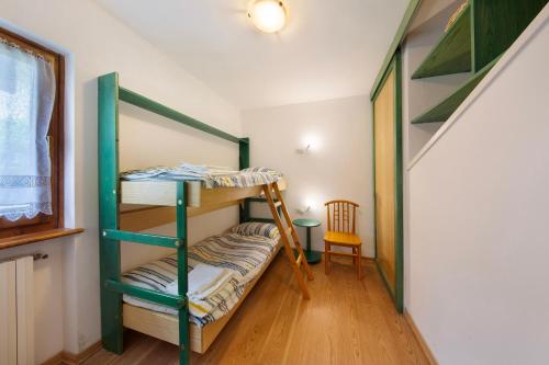Zimmer mit 2 Etagenbetten und einem Stuhl in der Unterkunft Appartamento Michaela a Vinigo in Vinigo