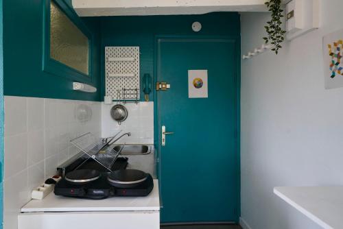 une cuisine avec une porte turquoise et une cuisinière dans l'établissement Lille Centre, Studio Idéal, à Lille
