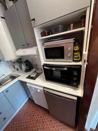 une petite cuisine avec un micro-ondes et un évier dans l'établissement Pla d'Adet- Studio 4 personnes Armazan, à Saint-Lary-Soulan