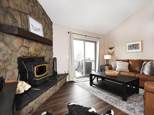 a living room with a couch and a stone fireplace at Meadowridge Court 19 Unit 1 in Fraser