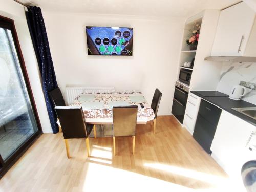 a small kitchen and dining room with a table and chairs at The Swans - Two-Bedroom City Centre House with Parking in Oxford