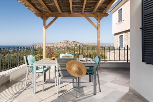 a patio with a table and chairs on a balcony at Lampetos Houses Molyvos in Mithymna