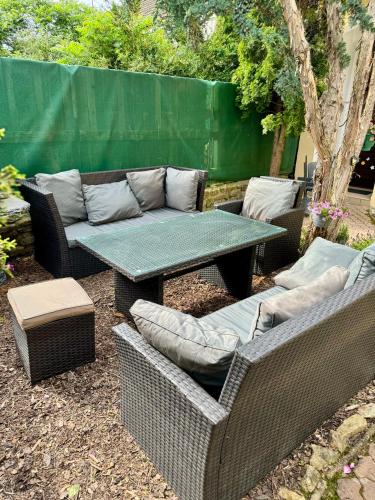 a patio with a table and wicker chairs and a couch at Ubytování U Pivovaru in Kamenice nad Lipou