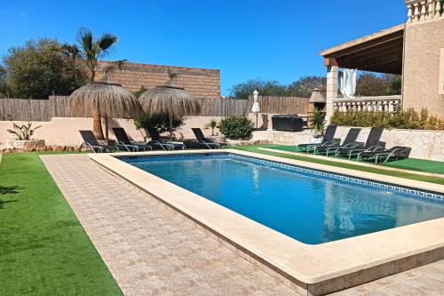 una piscina in un cortile con sedie di Villa Domingos by Slow Villas a Calas de Mallorca
